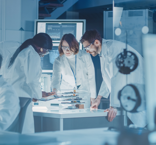Three scientists in white lab coats examine specimens and notes in a modern laboratory, conveying focused teamwork, research, and discovery.